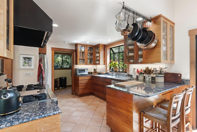 7 Linsdale Ln, Point Reyes Station, CA 94956 - kitchen featuring brown cabinets, a peninsula, a sink, light tile patterned floors, and ventilation hood