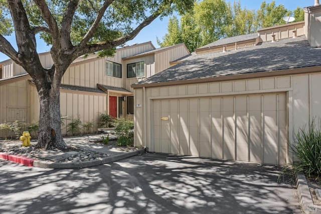 9 California Condor Way, Novato, CA 94949 - view of front of home featuring a garage, a shingled roof, board and batten siding, and asphalt driveway