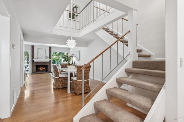 9 California Condor Way, Novato, CA 94949 - stairs with wood finished floors, a brick fireplace, a chandelier, and baseboards