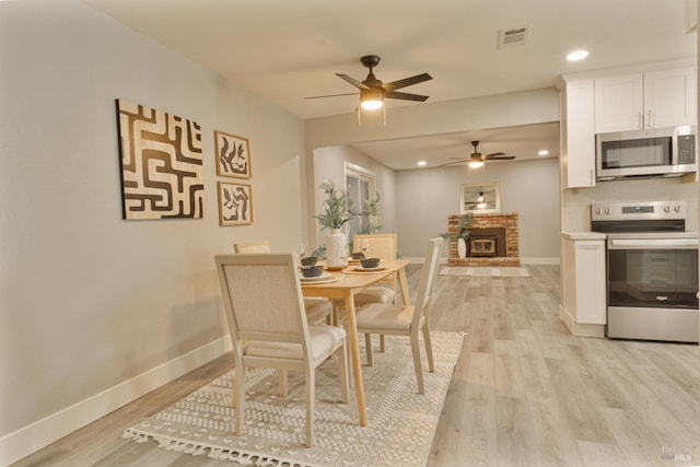 50 Montego Ct, Suisun City, CA 94585 - dining space featuring a ceiling fan, light wood-style flooring, a fireplace, and recessed lighting