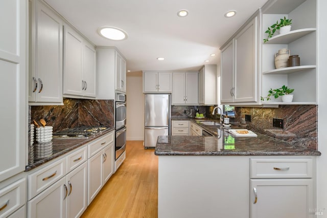 5 Crescent Cir, Fairfax, CA 94930 - kitchen featuring appliances with stainless steel finishes, open shelves, a sink, light wood-type flooring, and dark stone counters
