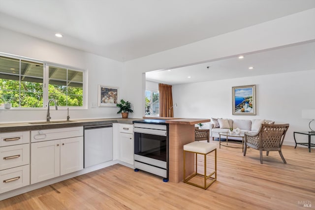 3641 Evergreen Ct, Napa, CA 94558 - kitchen with stainless steel dishwasher, a sink, a peninsula, open floor plan, and light wood-type flooring