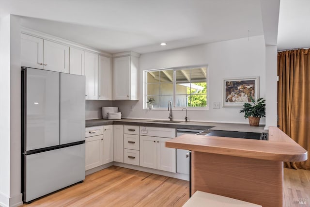 3641 Evergreen Ct, Napa, CA 94558 - kitchen with stainless steel refrigerator, a sink, light wood finished floors, white cabinets, and recessed lighting