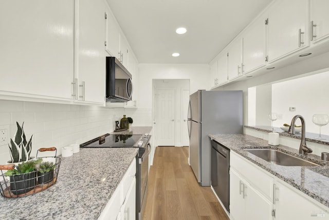 21100 Gary Dr Unit 215, Hayward, CA 94546 - kitchen featuring appliances with stainless steel finishes, a sink, light wood-style flooring, white cabinetry, and tasteful backsplash