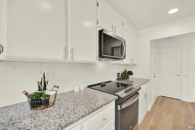 21100 Gary Dr Unit 215, Hayward, CA 94546 - kitchen with stainless steel appliances, white cabinets, light wood-style flooring, and light stone counters