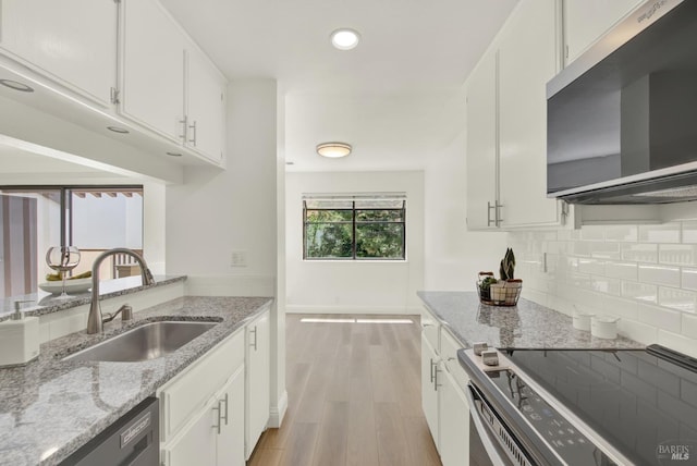 21100 Gary Dr Unit 215, Hayward, CA 94546 - kitchen featuring appliances with stainless steel finishes, a sink, light wood finished floors, decorative backsplash, and baseboards