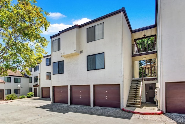 21100 Gary Dr Unit 215, Hayward, CA 94546 - view of front of property with stucco siding, an attached garage, driveway, stairway, and a balcony
