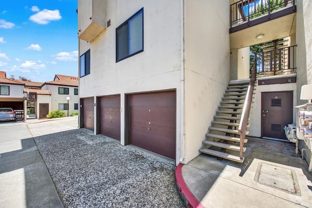 21100 Gary Dr Unit 215, Hayward, CA 94546 - view of property exterior featuring a garage, a balcony, and stucco siding