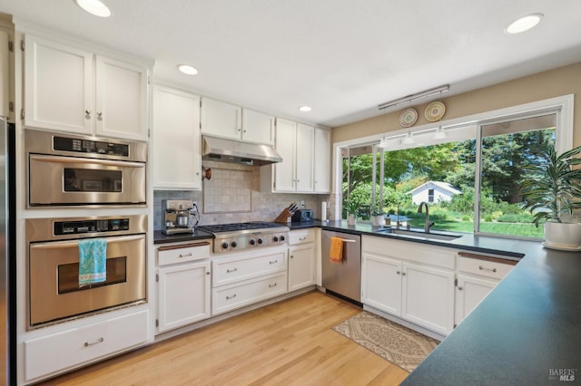 291 Maple Ave, Kenwood, CA 95452 - kitchen featuring stainless steel appliances, a sink, under cabinet range hood, dark countertops, and white cabinetry