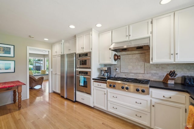 291 Maple Ave, Kenwood, CA 95452 - kitchen with appliances with stainless steel finishes, under cabinet range hood, dark countertops, decorative backsplash, and light wood-style floors