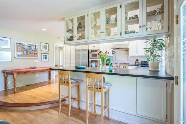 291 Maple Ave, Kenwood, CA 95452 - bar area with stainless steel refrigerator, light wood finished floors, under cabinet range hood, backsplash, and recessed lighting
