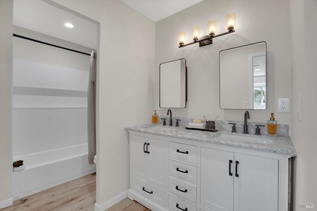 323 Larkin Ct, Benicia, CA 94510 - bathroom with double vanity, wood finished floors, bathing tub / shower combination, and baseboards