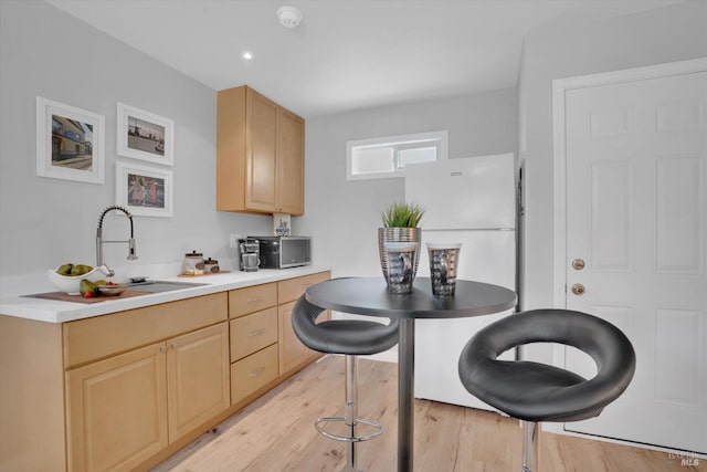 323 Larkin Ct, Benicia, CA 94510 - kitchen featuring light brown cabinetry, freestanding refrigerator, light wood-style floors, and a sink