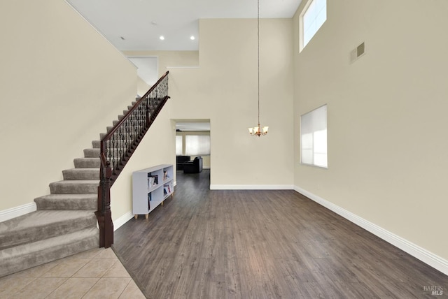 2467 Flatley Cir, Fairfield, CA 94533 - unfurnished living room with stairway, a chandelier, a towering ceiling, baseboards, and healthy amount of natural light