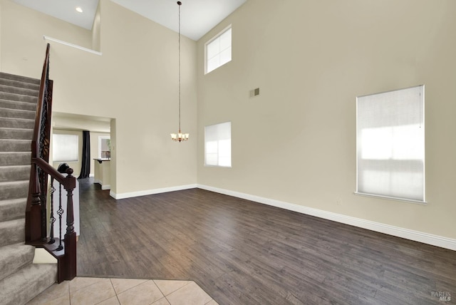 2467 Flatley Cir, Fairfield, CA 94533 - unfurnished living room with a high ceiling, stairs, baseboards, a chandelier, and wood finished floors