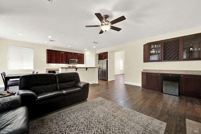 2467 Flatley Cir, Fairfield, CA 94533 - living room with beverage cooler, a bar, dark wood-style flooring, a ceiling fan, and baseboards