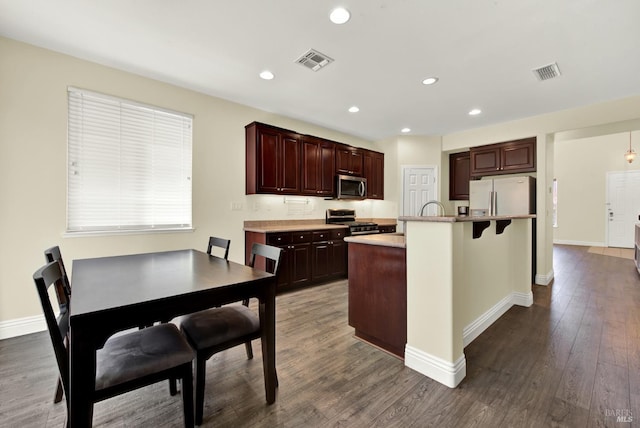 2467 Flatley Cir, Fairfield, CA 94533 - kitchen with appliances with stainless steel finishes, light countertops, dark wood-style floors, recessed lighting, and an island with sink