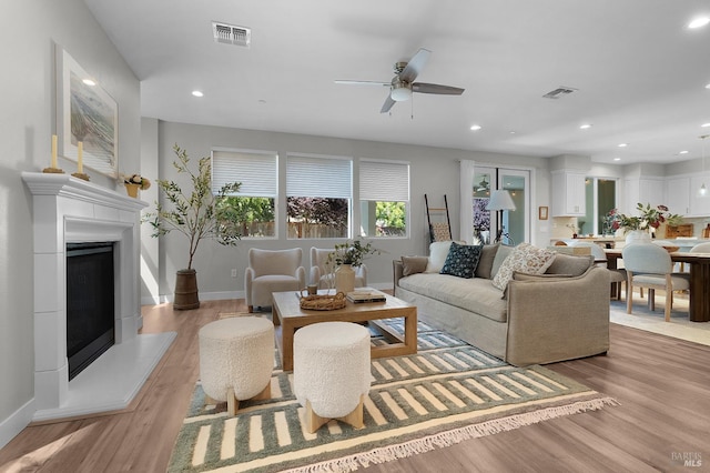 2579 Estery Ln, Santa Rosa, CA 95403 - living area featuring light wood-style floors, a ceiling fan, a fireplace with raised hearth, baseboards, and recessed lighting