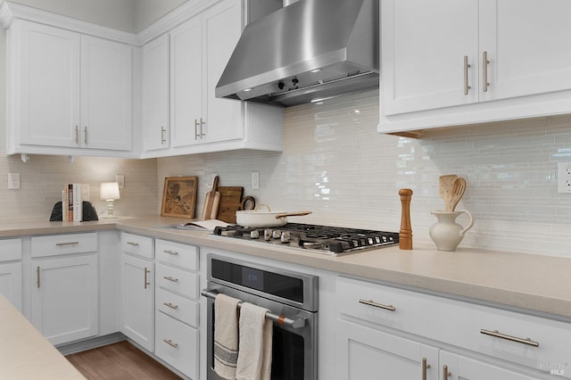2579 Estery Ln, Santa Rosa, CA 95403 - kitchen featuring wall chimney exhaust hood, appliances with stainless steel finishes, light countertops, white cabinetry, and tasteful backsplash