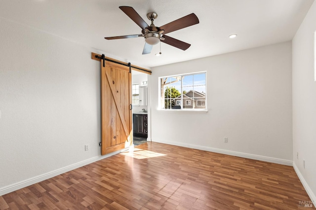 1039 Aston Cir, Santa Rosa, CA 95404 - unfurnished room featuring a barn door, a ceiling fan, wood finished floors, recessed lighting, and baseboards