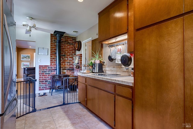 5851 Vine Hill Rd, Sebastopol, CA 95472 - kitchen with a wood stove, freestanding refrigerator, light countertops, brown cabinets, and a ceiling fan