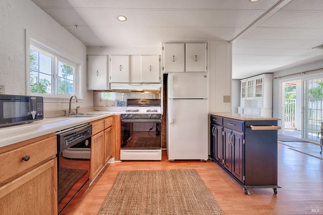 5851 Vine Hill Rd, Sebastopol, CA 95472 - kitchen featuring black appliances, a sink, under cabinet range hood, light wood-style flooring, and light countertops