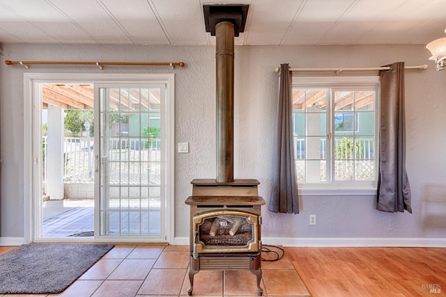 5851 Vine Hill Rd, Sebastopol, CA 95472 - doorway featuring a wood stove, baseboards, a textured wall, and wood finished floors