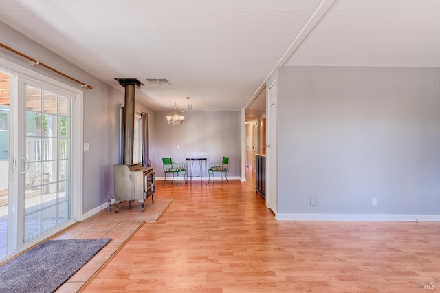 5851 Vine Hill Rd, Sebastopol, CA 95472 - interior space featuring light wood-style floors, a wood stove, a chandelier, and baseboards