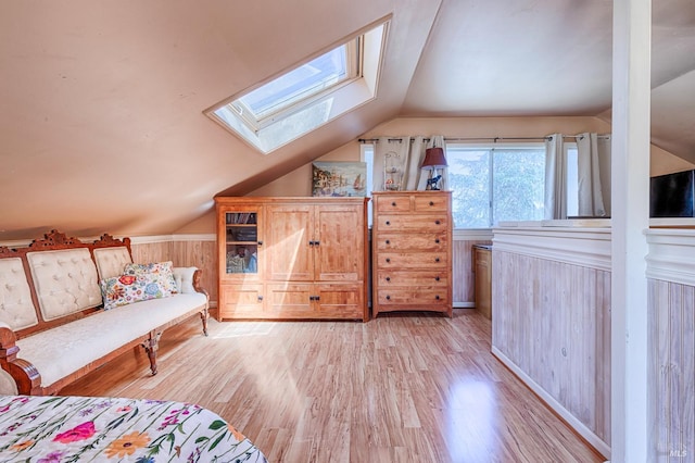 5851 Vine Hill Rd, Sebastopol, CA 95472 - bedroom featuring a skylight, vaulted ceiling, light wood finished floors, a wainscoted wall, and wood walls