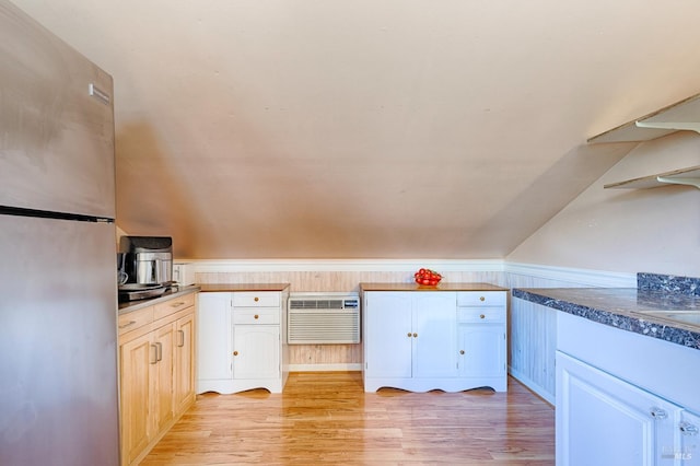 5851 Vine Hill Rd, Sebastopol, CA 95472 - kitchen featuring freestanding refrigerator, light wood finished floors, a wall mounted air conditioner, dark countertops, and white cabinets