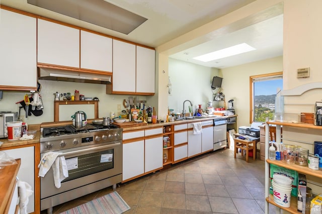 221 Tiburon Blvd, San Rafael, CA 94901 - kitchen with gas range, range hood, white cabinets, and a sink