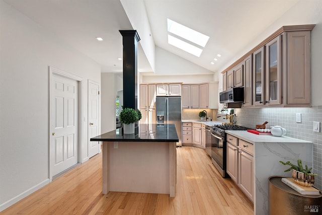 1 Courtney Ln, Mill Valley, CA 94941 - kitchen with appliances with stainless steel finishes, a skylight, vaulted ceiling, tasteful backsplash, and a center island