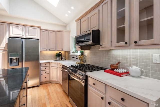 1 Courtney Ln, Mill Valley, CA 94941 - kitchen with stainless steel appliances, a sink, light wood finished floors, vaulted ceiling, and backsplash