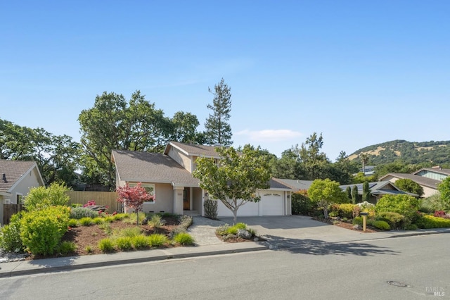 1263 Simmons Ln, Novato, CA 94945 - view of property hidden behind natural elements featuring concrete driveway, a garage, stucco siding, and a mountain view