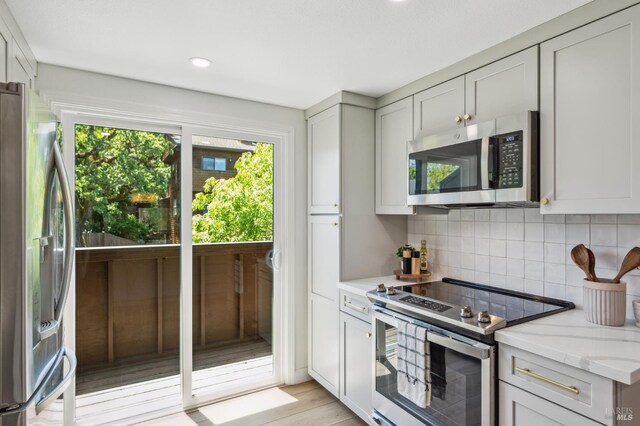 13 Freedom Ln S, Petaluma, CA 94952 - kitchen featuring stainless steel appliances, tasteful backsplash, light stone countertops, light wood finished floors, and recessed lighting