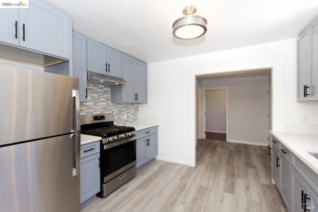 5817 Seminary Ct, Oakland, CA 94605 - kitchen with appliances with stainless steel finishes, under cabinet range hood, decorative backsplash, light countertops, and light wood-type flooring