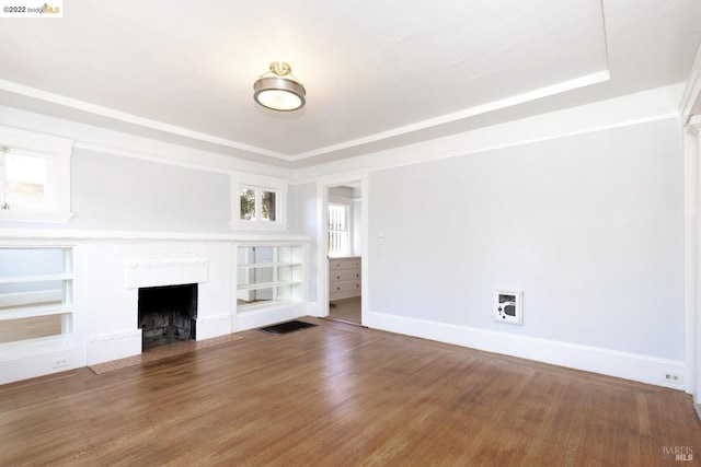 5817 Seminary Ct, Oakland, CA 94605 - unfurnished living room featuring a tray ceiling, a fireplace with flush hearth, baseboards, wood finished floors, and heating unit