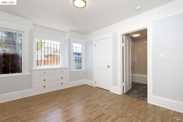 5817 Seminary Ct, Oakland, CA 94605 - unfurnished bedroom featuring light wood-style floors, baseboards, and connected bathroom