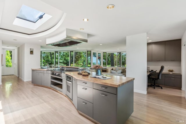 5768 Silverado Trl, Napa, CA 94558 - kitchen featuring butcher block counters, a skylight, oven, gray cabinets, and recessed lighting