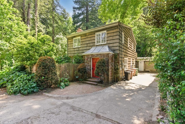121 W Blithedale Ave, Mill Valley, CA 94941 - view of front facade featuring concrete driveway, a standing seam roof, and a chimney