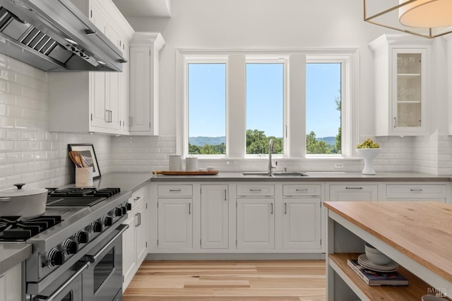 30 Sandy Ln, Mill Valley, CA 94941 - kitchen with extractor fan, double oven range, a sink, white cabinetry, and light wood finished floors