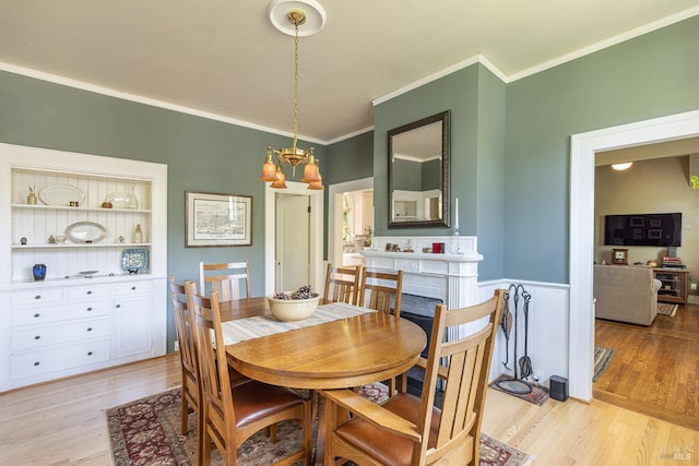 406 Franklin St, Napa, CA 94559 - dining room with crown molding, a chandelier, light wood-style flooring, and a wainscoted wall