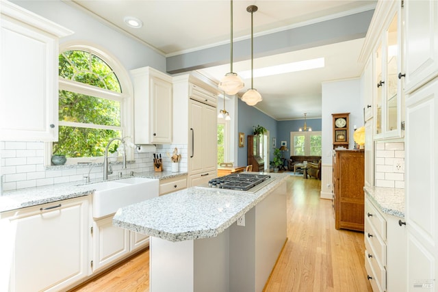 406 Franklin St, Napa, CA 94559 - kitchen featuring stainless steel gas stovetop, a sink, ornamental molding, a center island, and light wood-style flooring