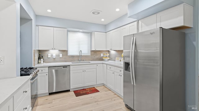 265 Chestnut St, Dixon, CA 95620 - kitchen with stainless steel appliances, a sink, white cabinets, backsplash, and light countertops