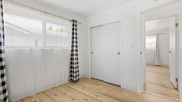 265 Chestnut St, Dixon, CA 95620 - unfurnished bedroom featuring multiple windows, light wood-style floors, a closet, and baseboards