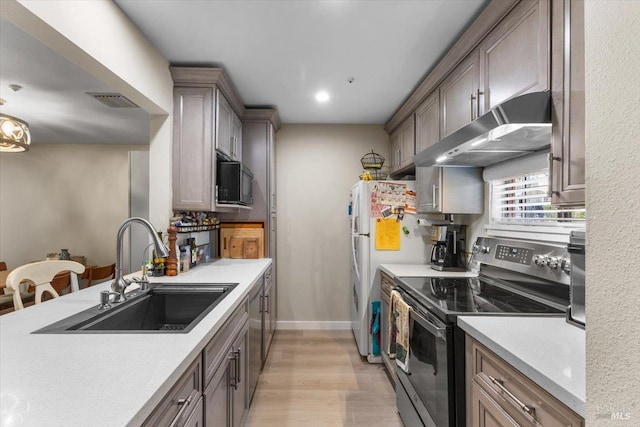 319 N St Unit 2, Healdsburg, CA 95448 - kitchen featuring stainless steel electric range oven, under cabinet range hood, a sink, light wood-type flooring, and light countertops
