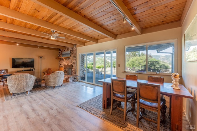 1961 Foothill Dr, Redwood Valley, CA 95470 - dining space featuring track lighting, wood ceiling with exposed beams, wood finished floors, a fireplace, and a ceiling fan