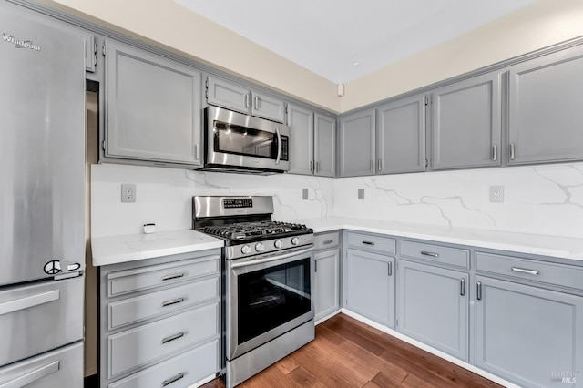 247 Clearpointe Dr, Vallejo, CA 94591 - kitchen with appliances with stainless steel finishes, gray cabinets, dark wood-style flooring, light stone countertops, and decorative backsplash