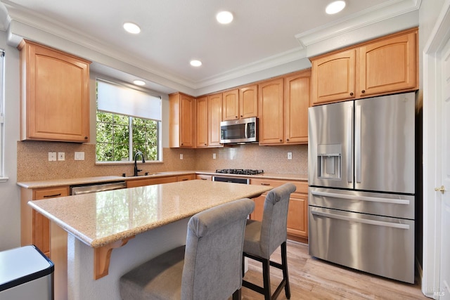 712 Tahoe Ct, Fairfield, CA 94534 - kitchen with stainless steel appliances, crown molding, light wood-style floors, a kitchen bar, and a center island