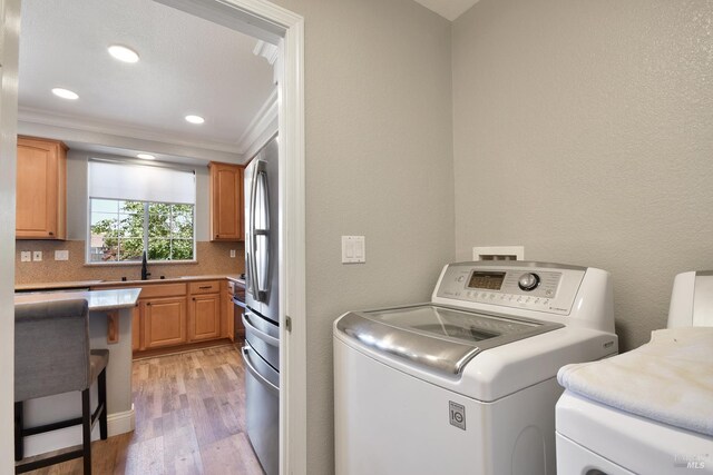 712 Tahoe Ct, Fairfield, CA 94534 - laundry room with light wood-type flooring, ornamental molding, independent washer and dryer, and recessed lighting